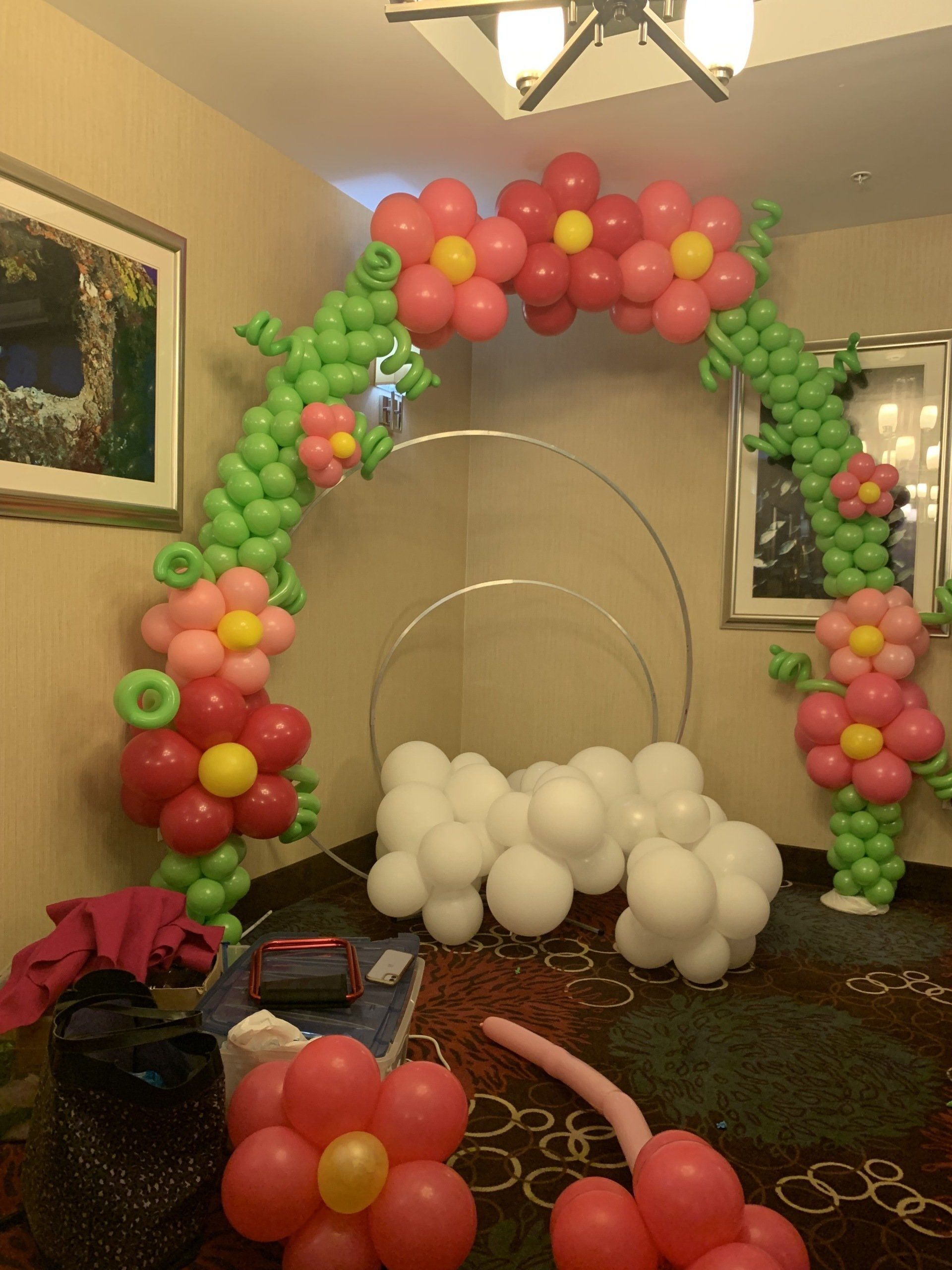 A room decorated with pink and green balloons and flowers