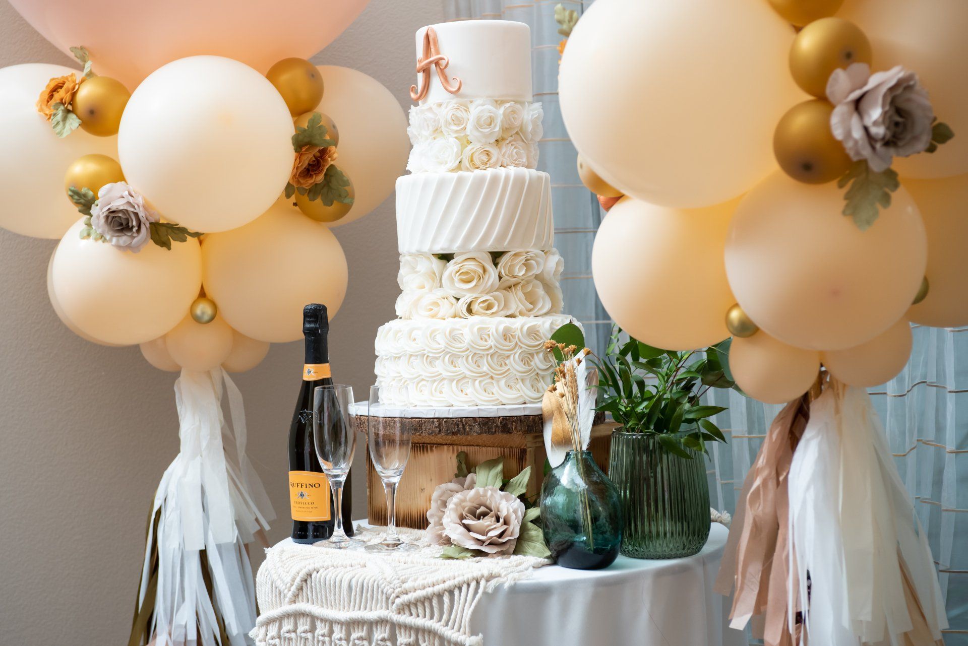 A wedding cake is sitting on top of a table surrounded by balloons.