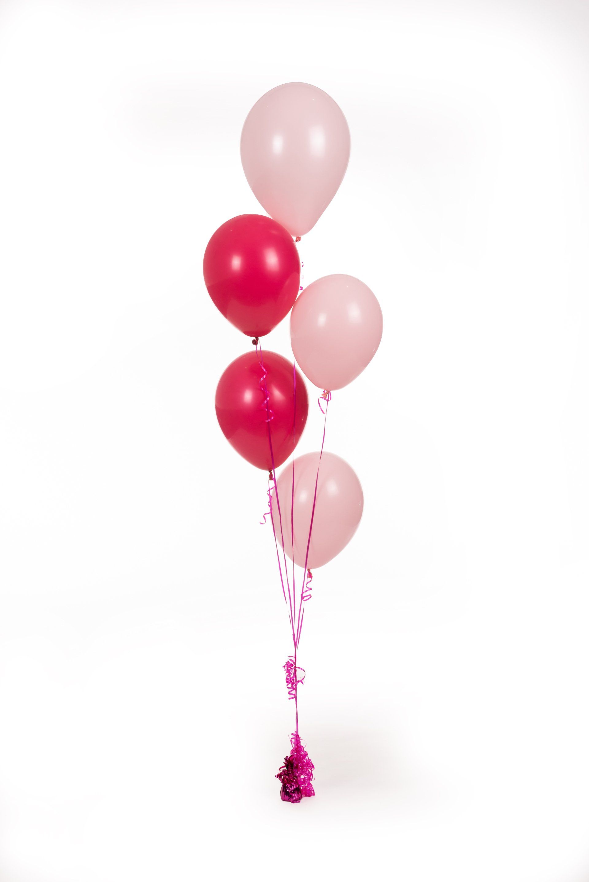 A bunch of pink and red balloons on a white background.