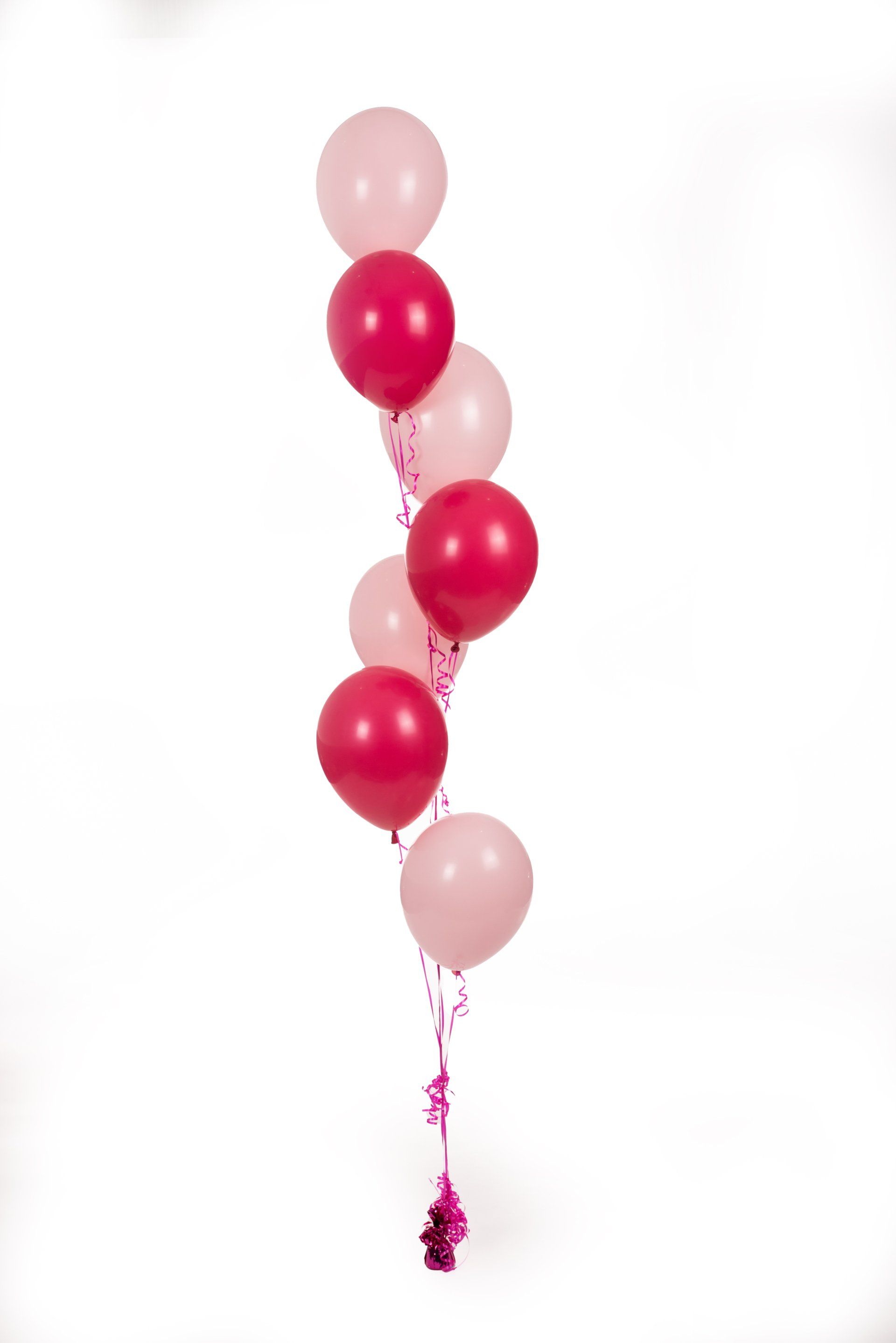 A bunch of pink and red balloons on a white background