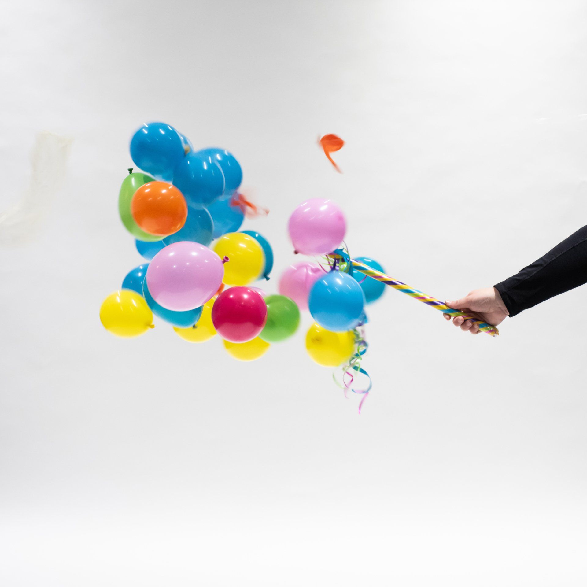 A person is holding a bunch of colorful balloons in their hand
