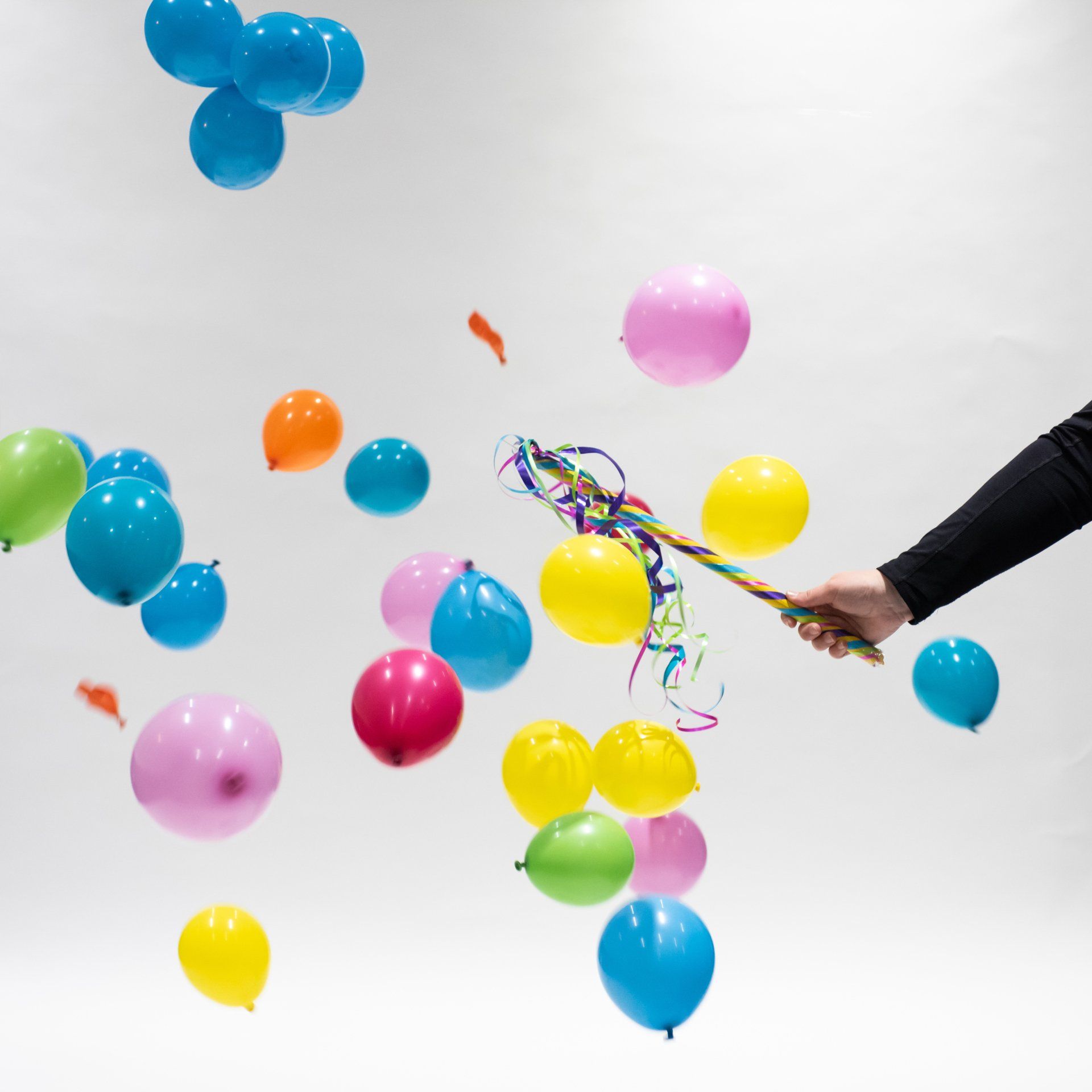 A person is throwing colorful balloons in the air
