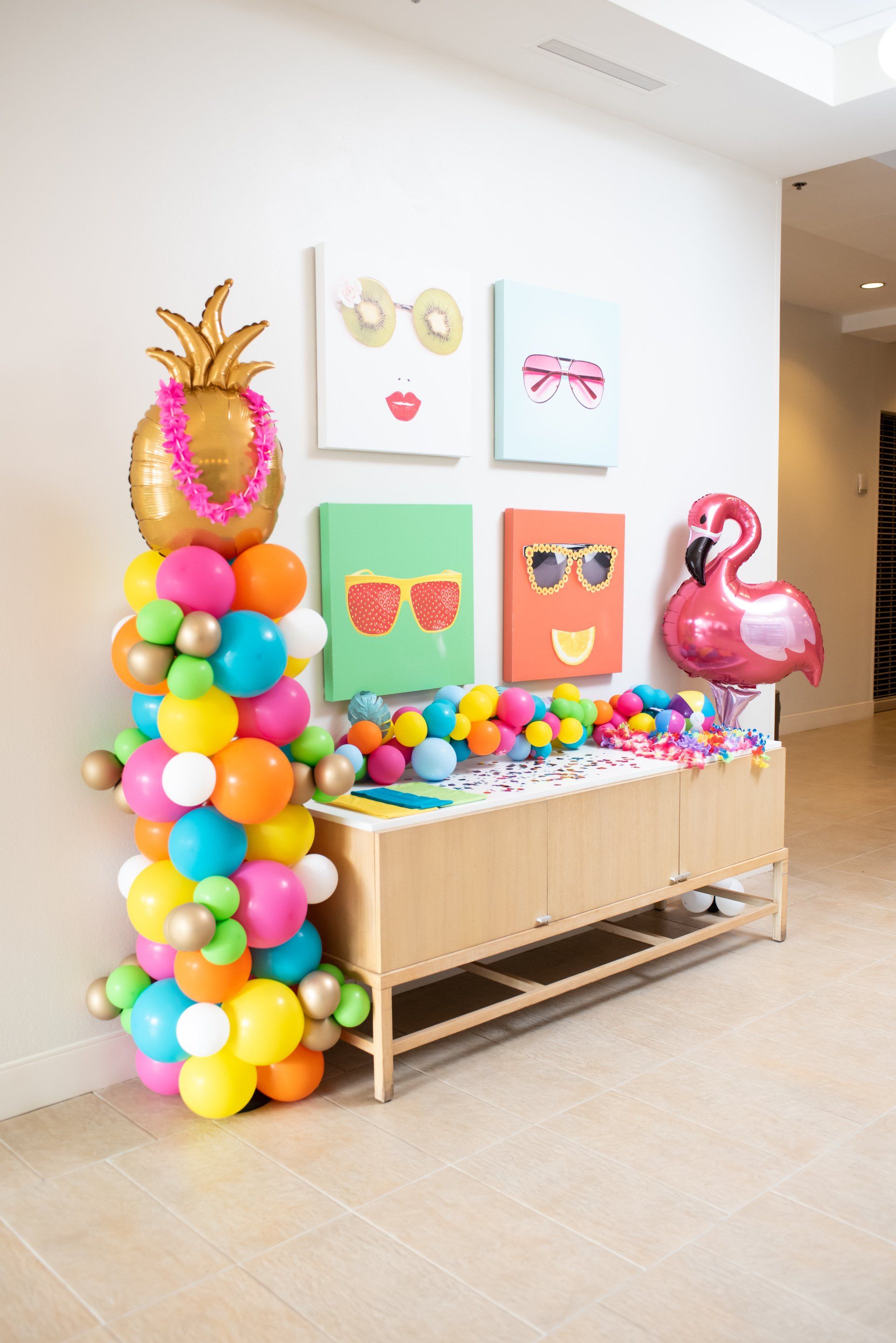 A bunch of colorful balloons are sitting on top of a wooden table.