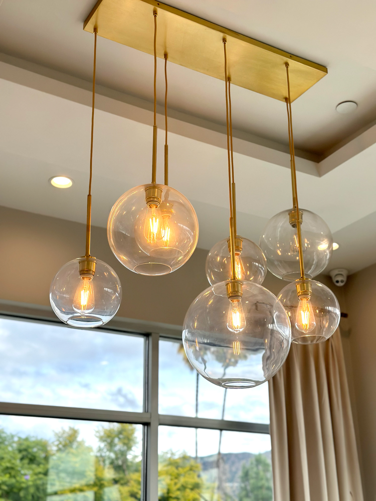 A bunch of clear glass pendant lights hanging from the ceiling