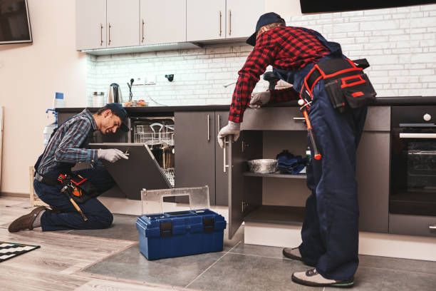 Men with tools repairing dishwasher