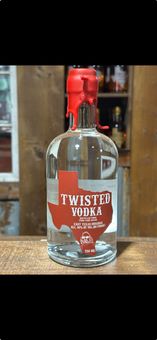 A bottle of twister vodka is sitting on a wooden table.