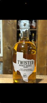 A bottle of twisted texas whiskey is sitting on a wooden table.