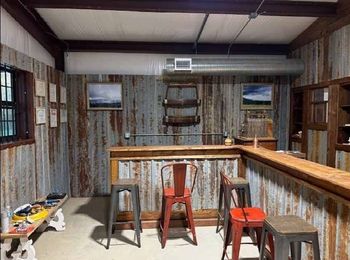 A room with a bar and stools in it.
