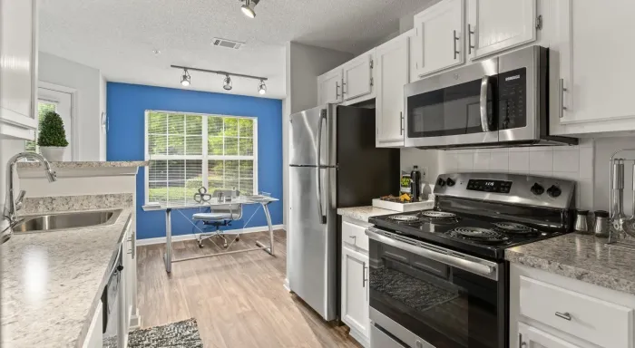 Kitchen with white countertops and stainless steel appliances at The Aubrey