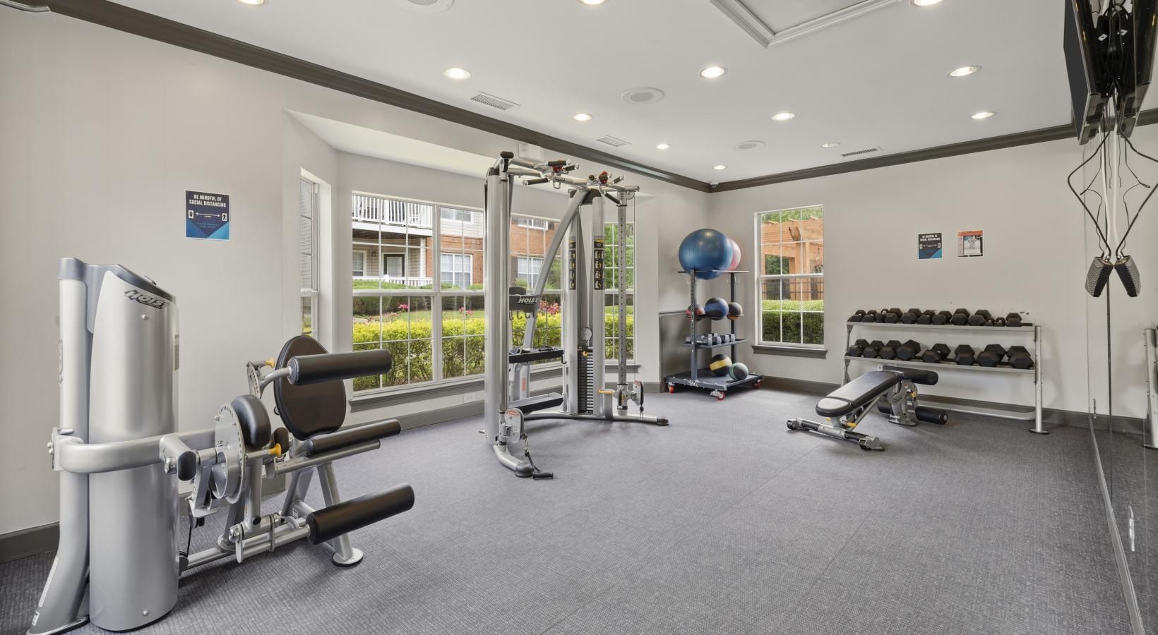 Fitness center with weight rack and leg machine at The Aubrey Sweetwater