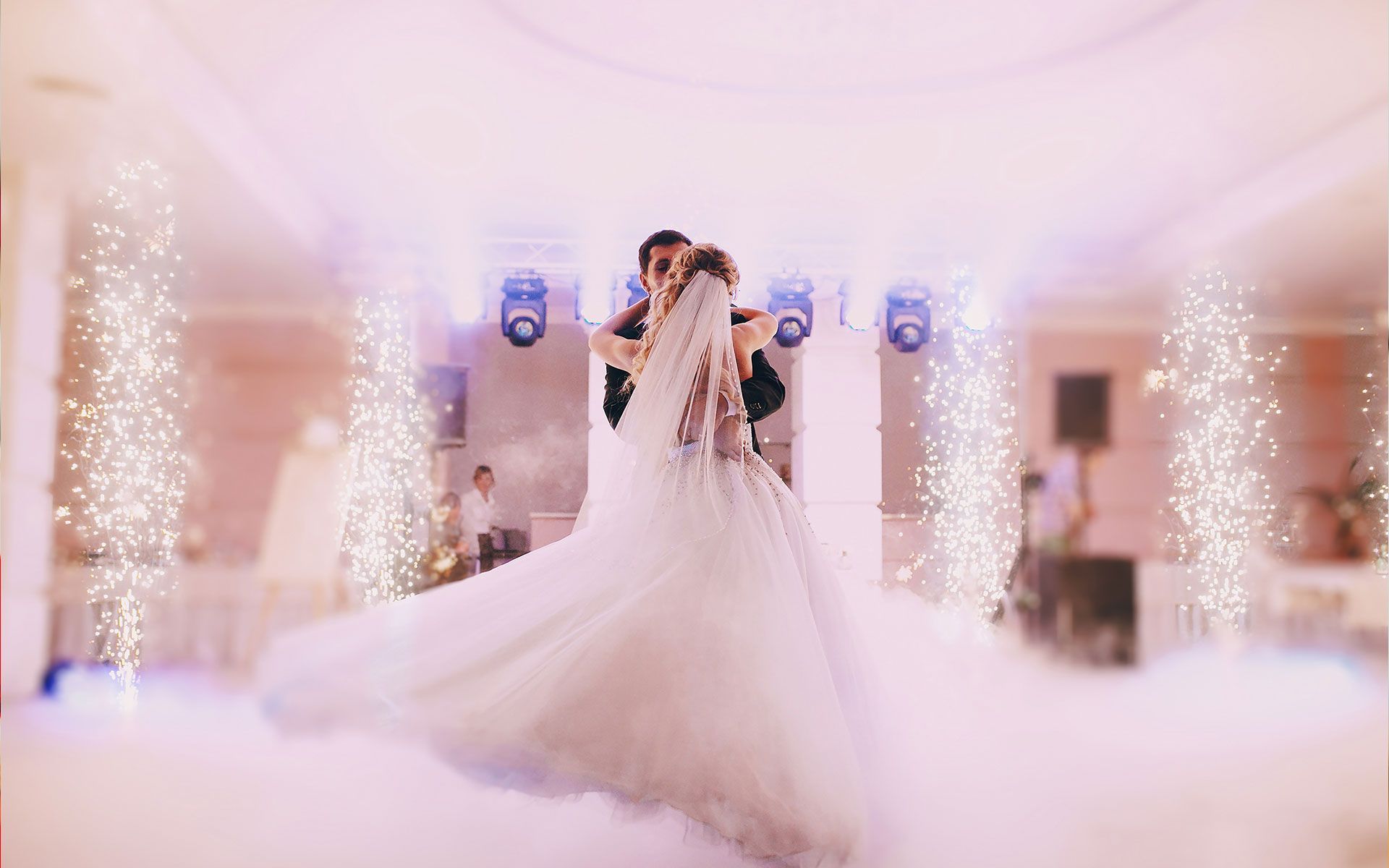 A bride and groom are dancing their first dance at their wedding reception.