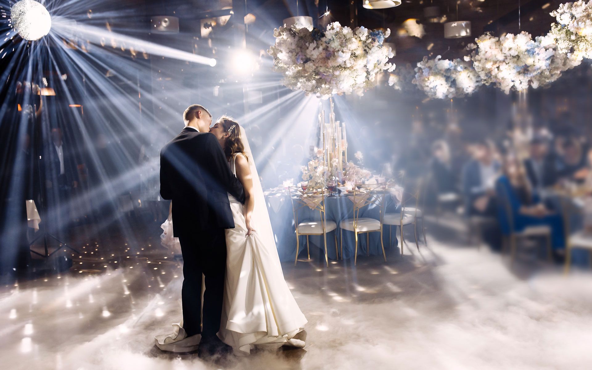 A bride and groom are dancing their first dance at their wedding reception.