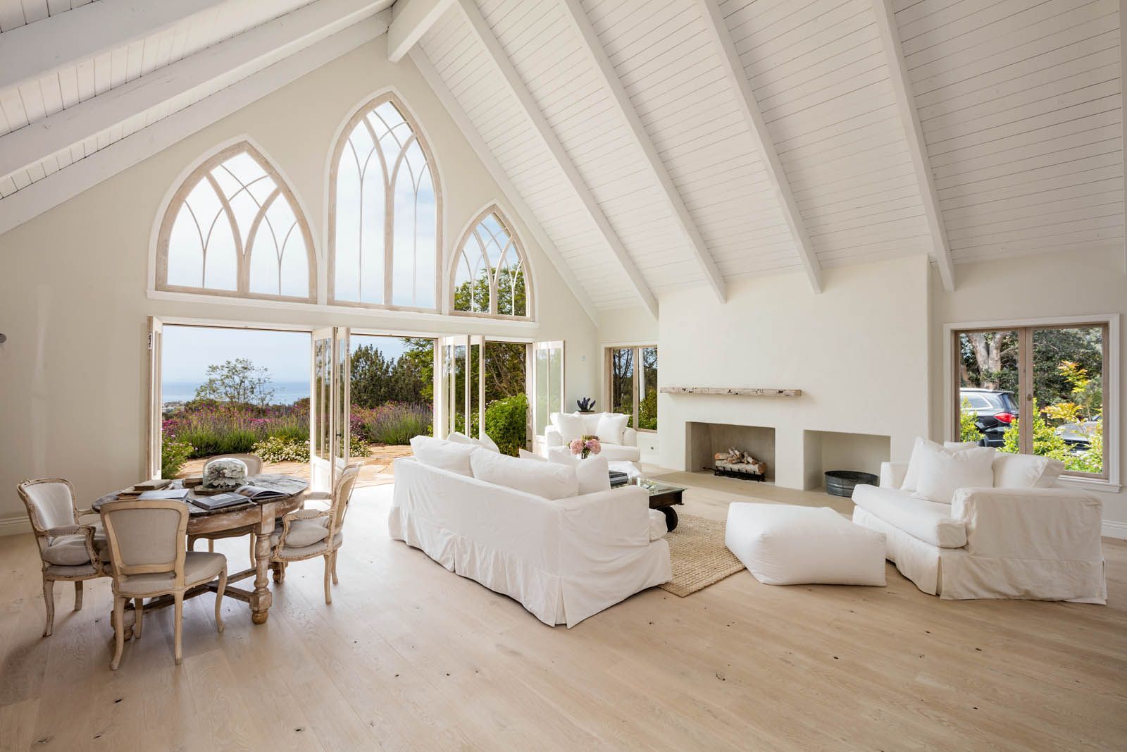 A living room with white furniture and a fireplace