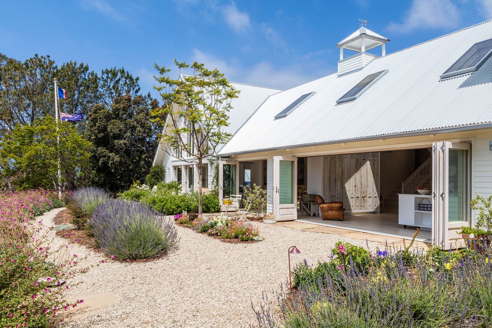 A large white house with a lot of windows and flowers in front of it.