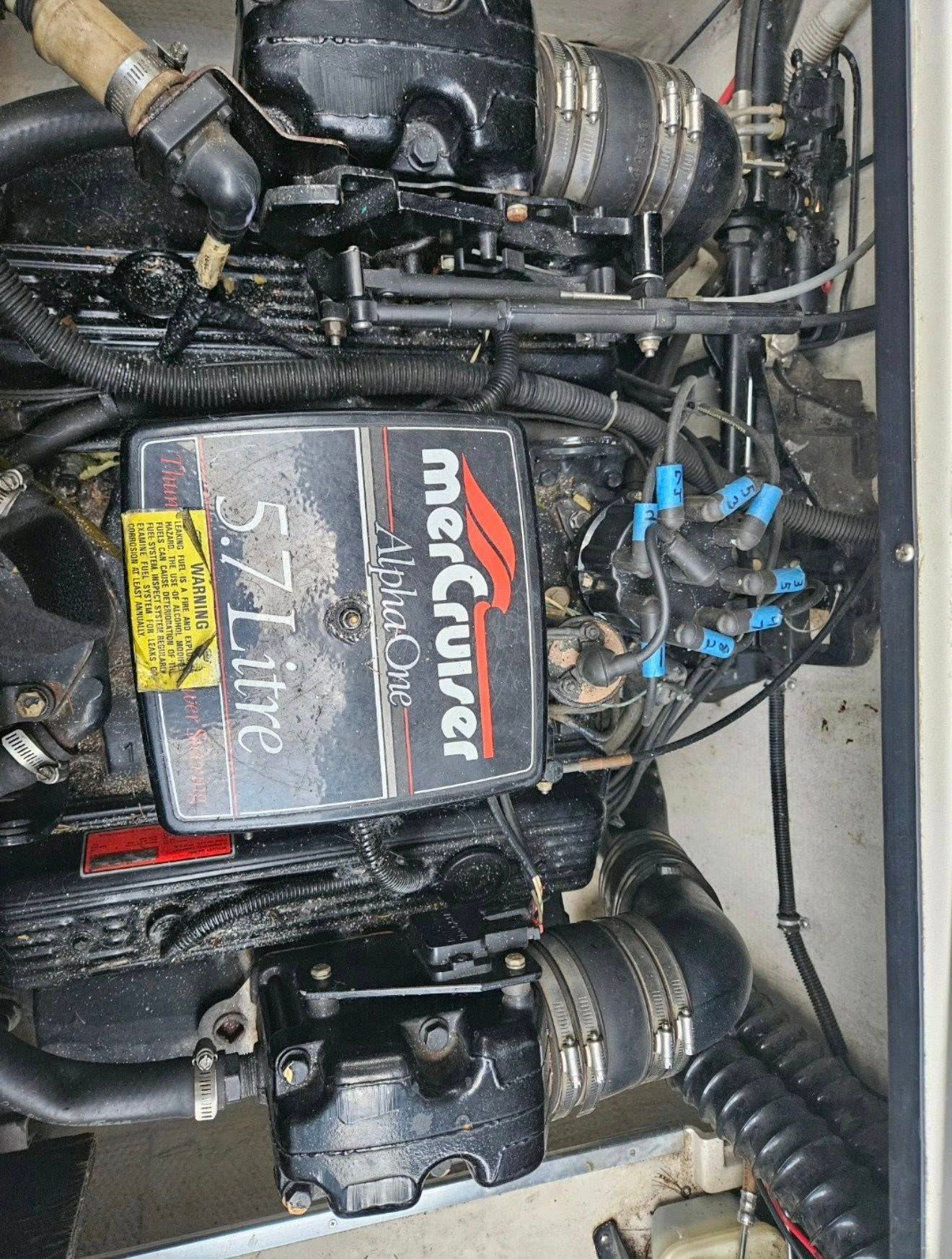 MerCruiser engine, 5.7L, Alpha One, installed in a boat, with various hoses and wiring visible.