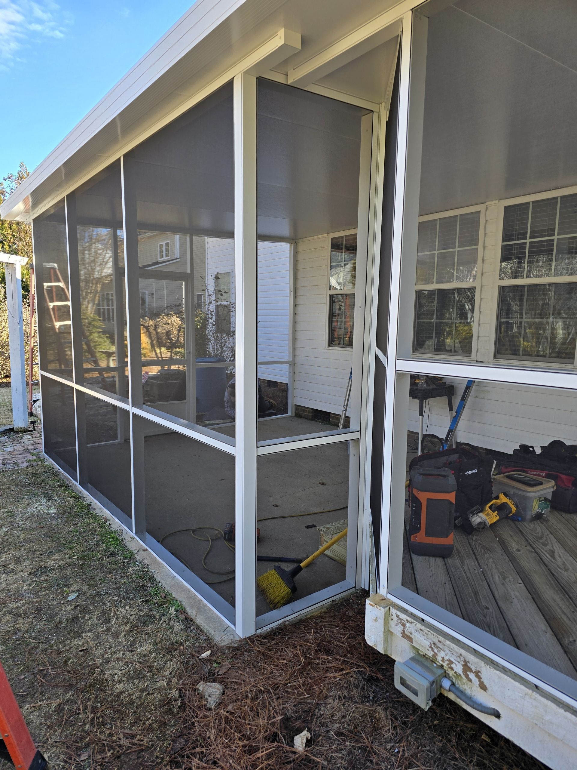 A screened in porch is being built on the side of a house.