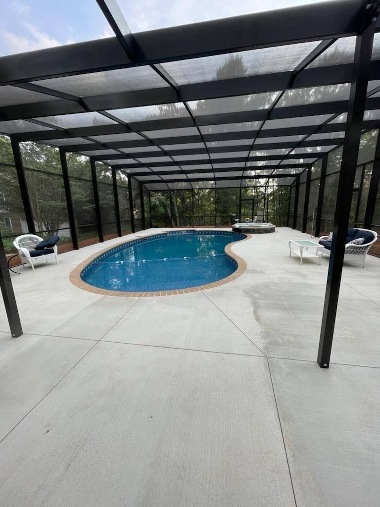 A large swimming pool is covered by a screened in area.