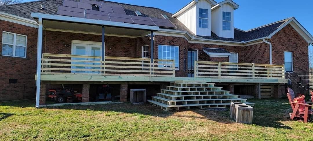 A large brick house with a large deck in the backyard.
