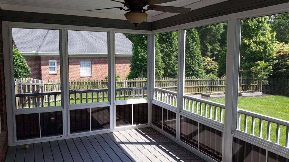 A screened in porch with a ceiling fan and a view of the backyard.