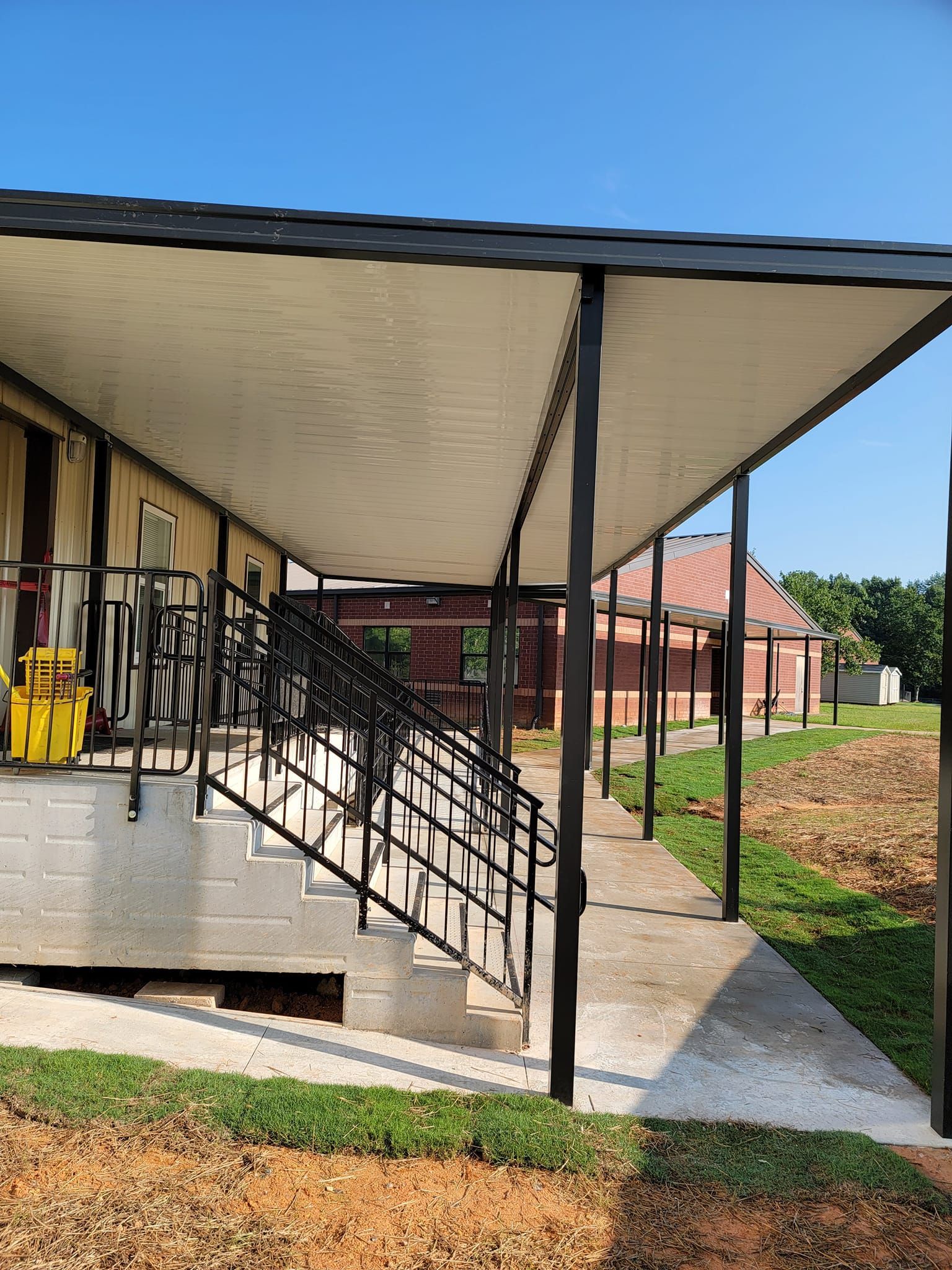 A covered walkway with stairs leading up to a building.