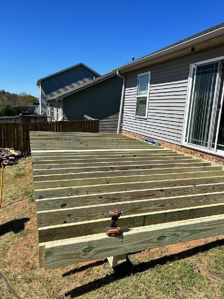 A wooden deck is being built in front of a house.