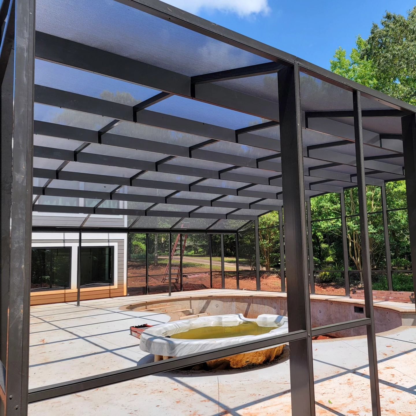 A swimming pool is under a clear roof