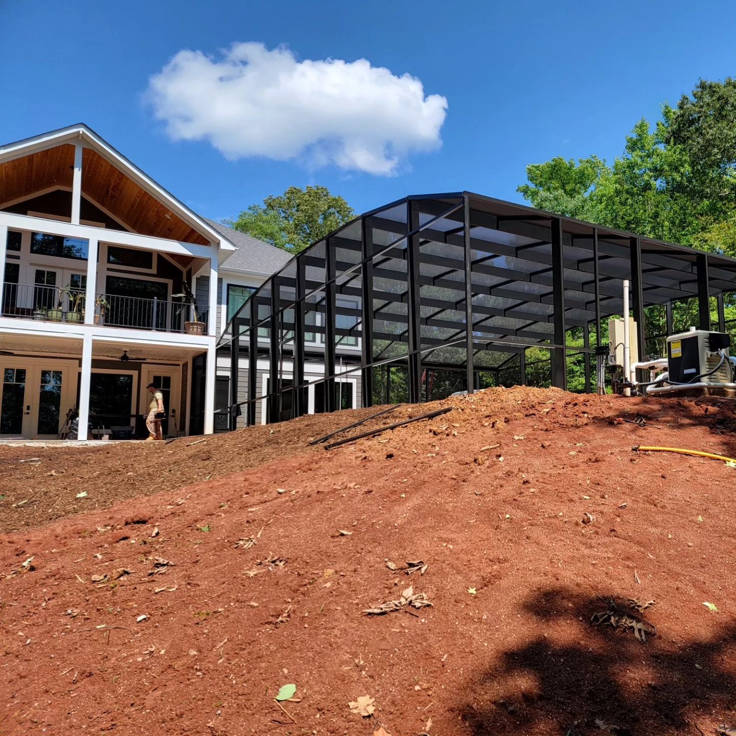 A large house is being built on top of a dirt hill