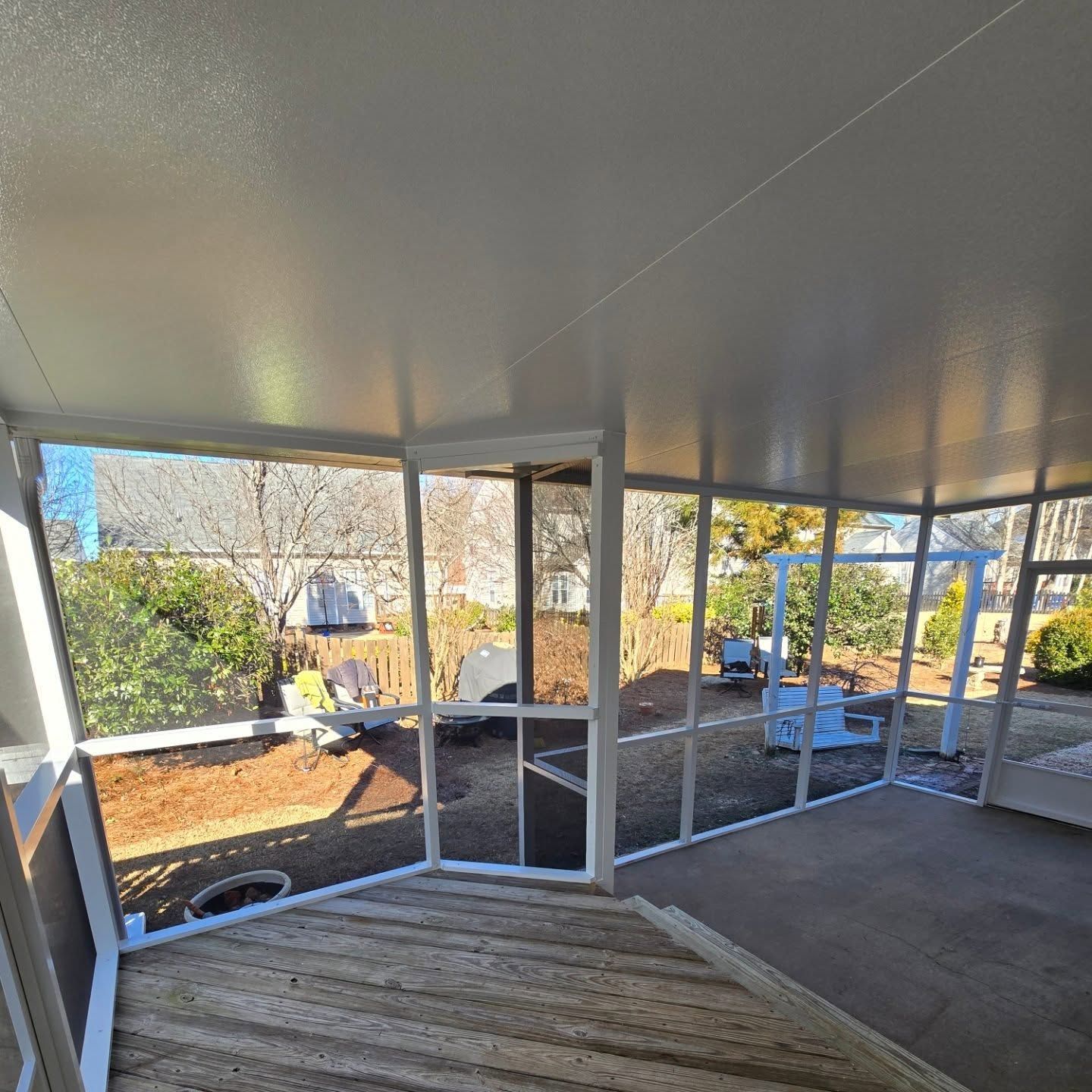 A screened in porch with a lot of windows and a ceiling.