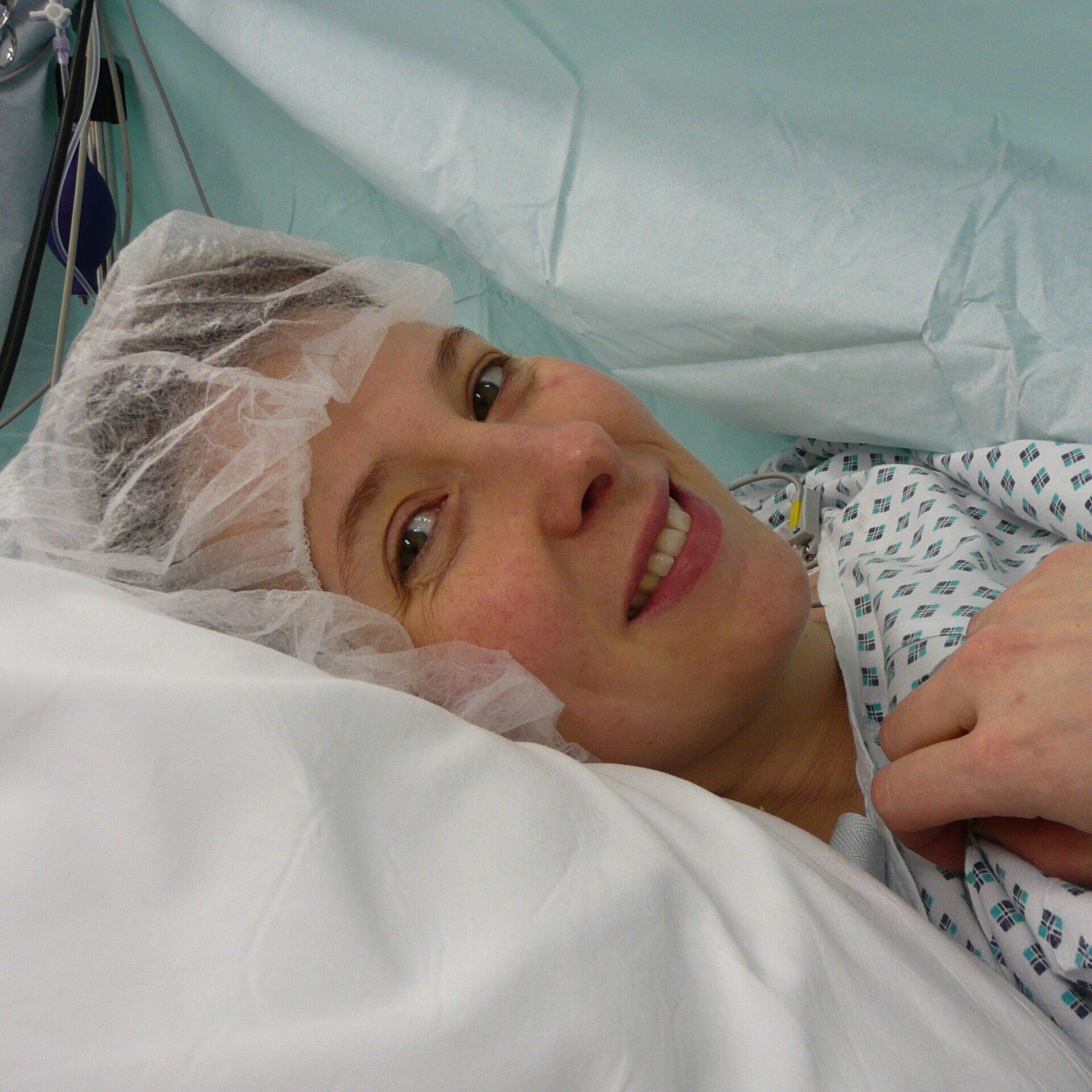 Woman smiling in hospital after birth by caesarean, sharing a positive experience