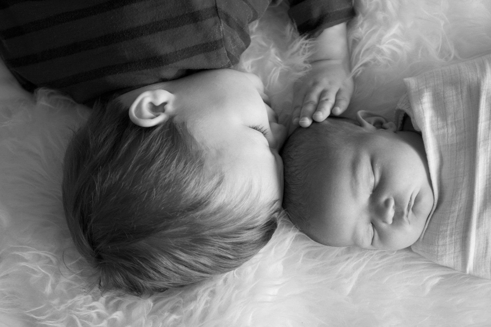 “Photo of newborn baby with older sibling, illustrating how a postnatal doula supports the whole family in London”