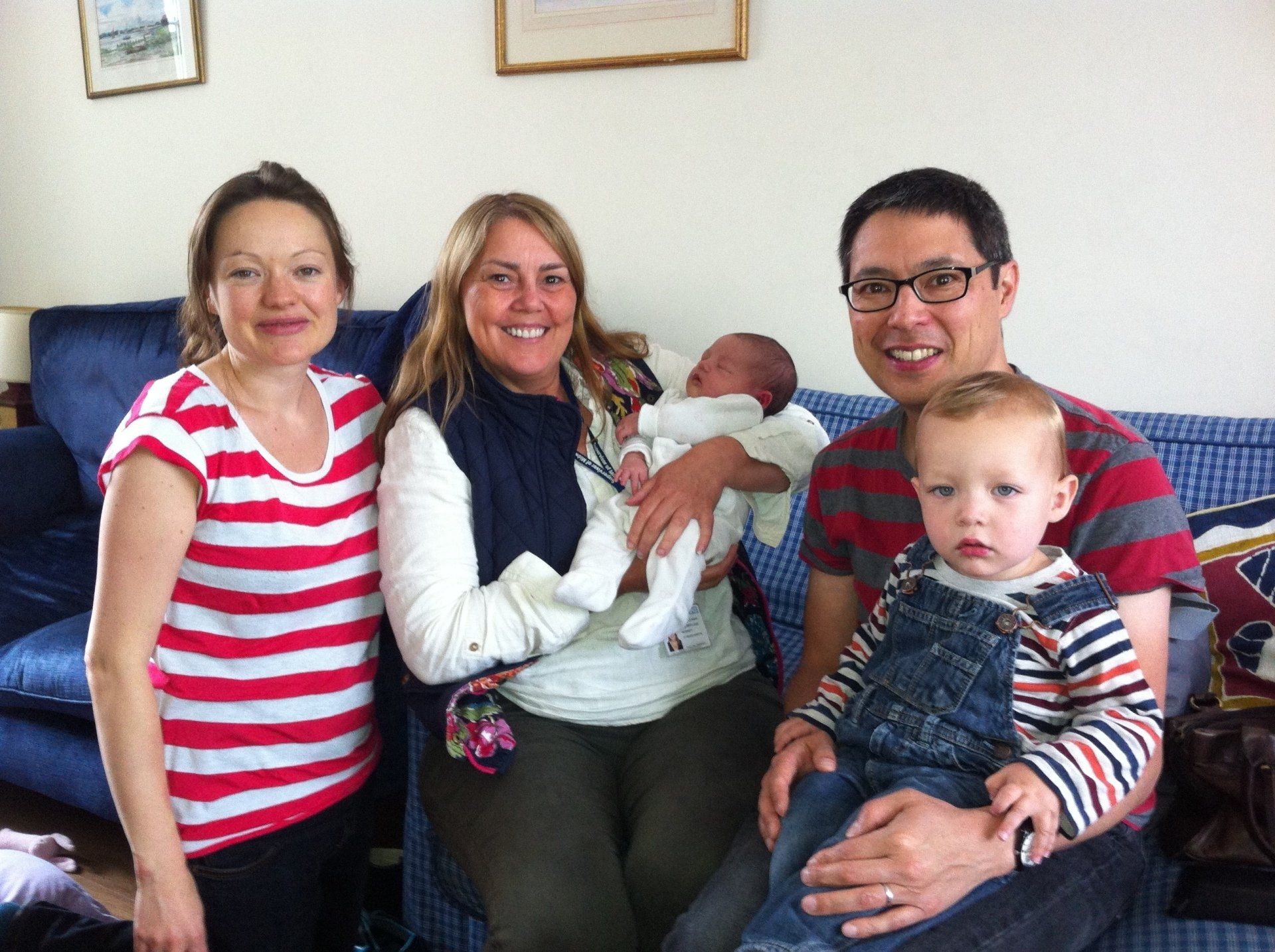 Family with newborn and toddler smiling after a positive birth experience shared on the podcast