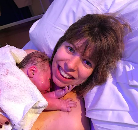 Mother holding newborn in hospital bed after birth, featured in My Positive Birth podcast