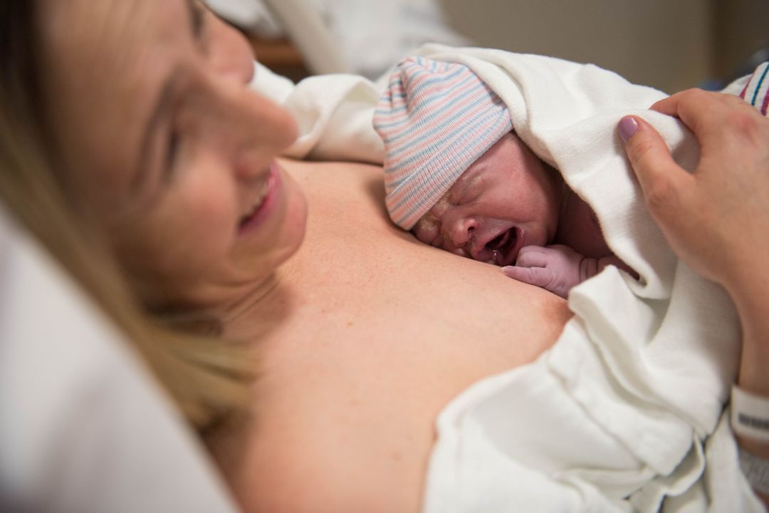 Woman Happy After a Positive Birth Holding Her Newborn Baby