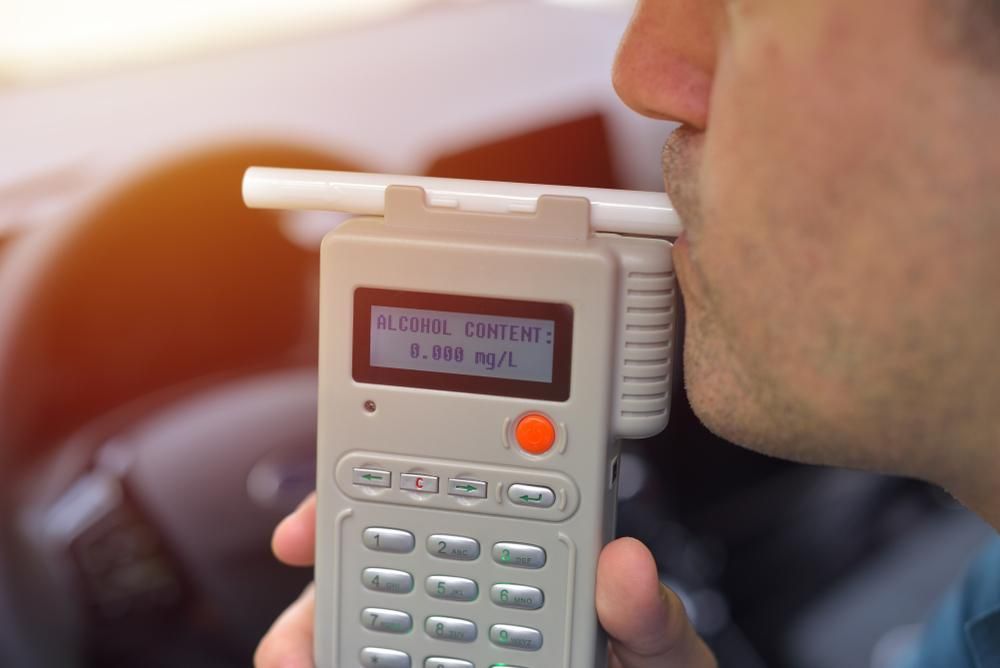 A Man is Drinking From a Breathalyzer in a Car — Waring's Auto Electrical in South Geelong, VIC