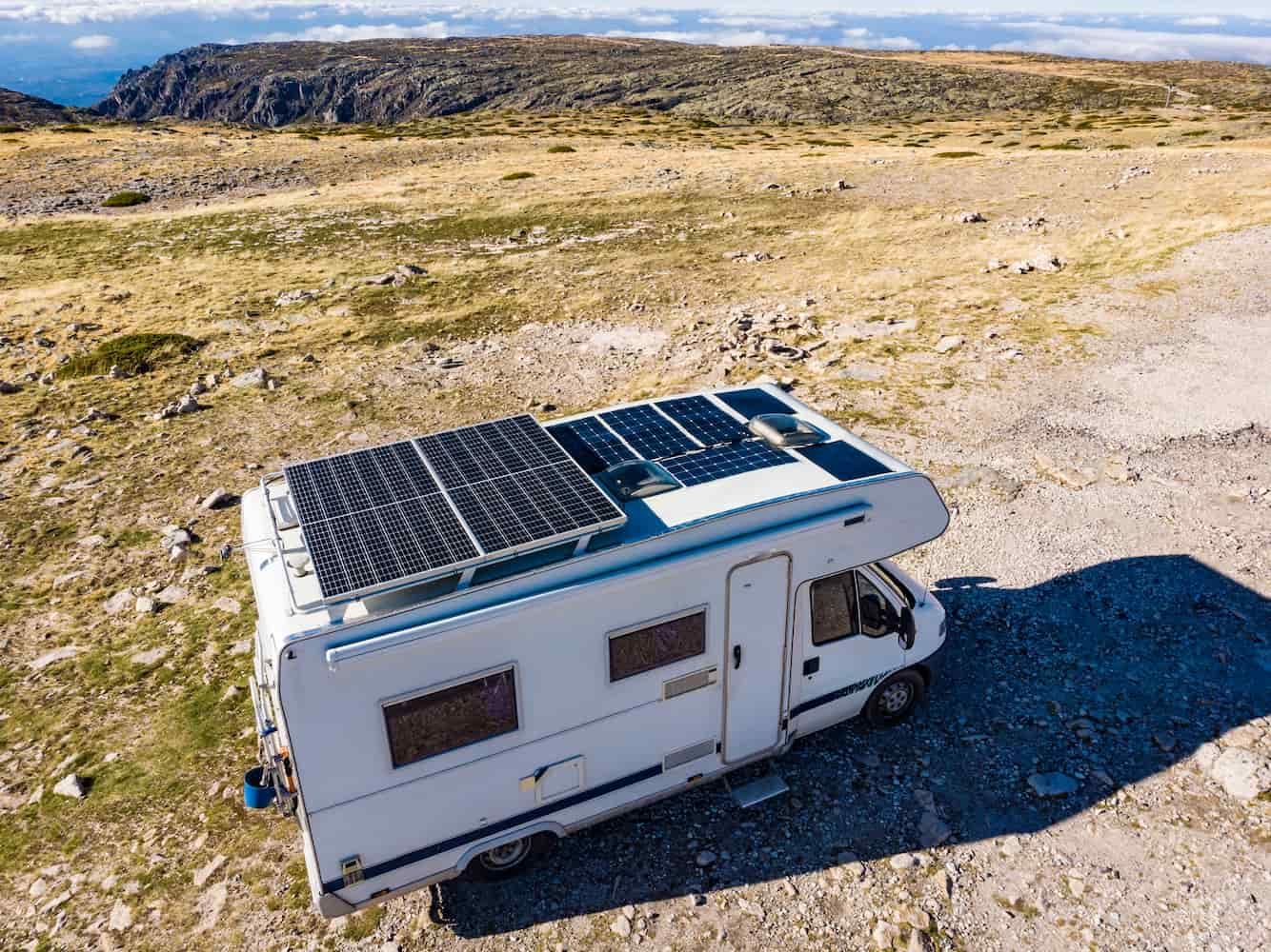 A RV With Solar Panels on the Roof is Parked on a Dirt Road — Waring's Auto Electrical in South Geelong, VIC