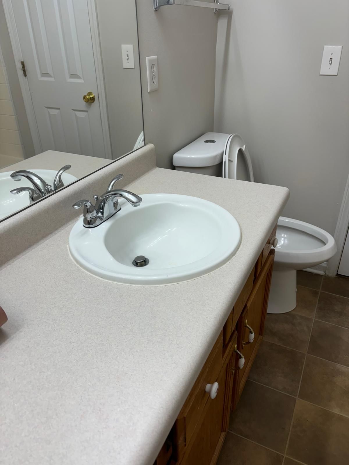 A bathroom with a sink , toilet and mirror.