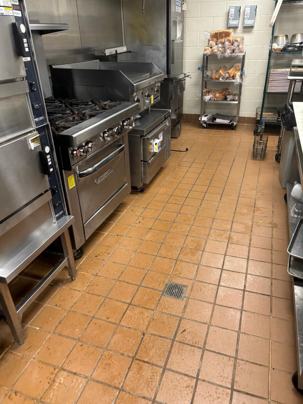 A kitchen with stainless steel appliances and tile floors.