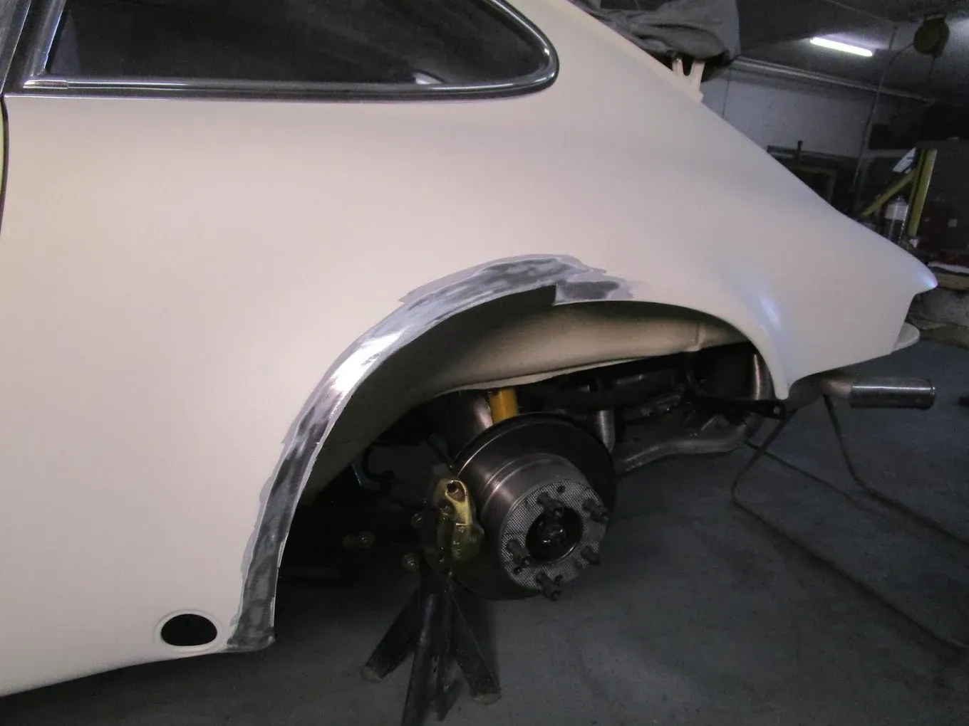 Une voiture blanche est en cours de réparation dans un garage