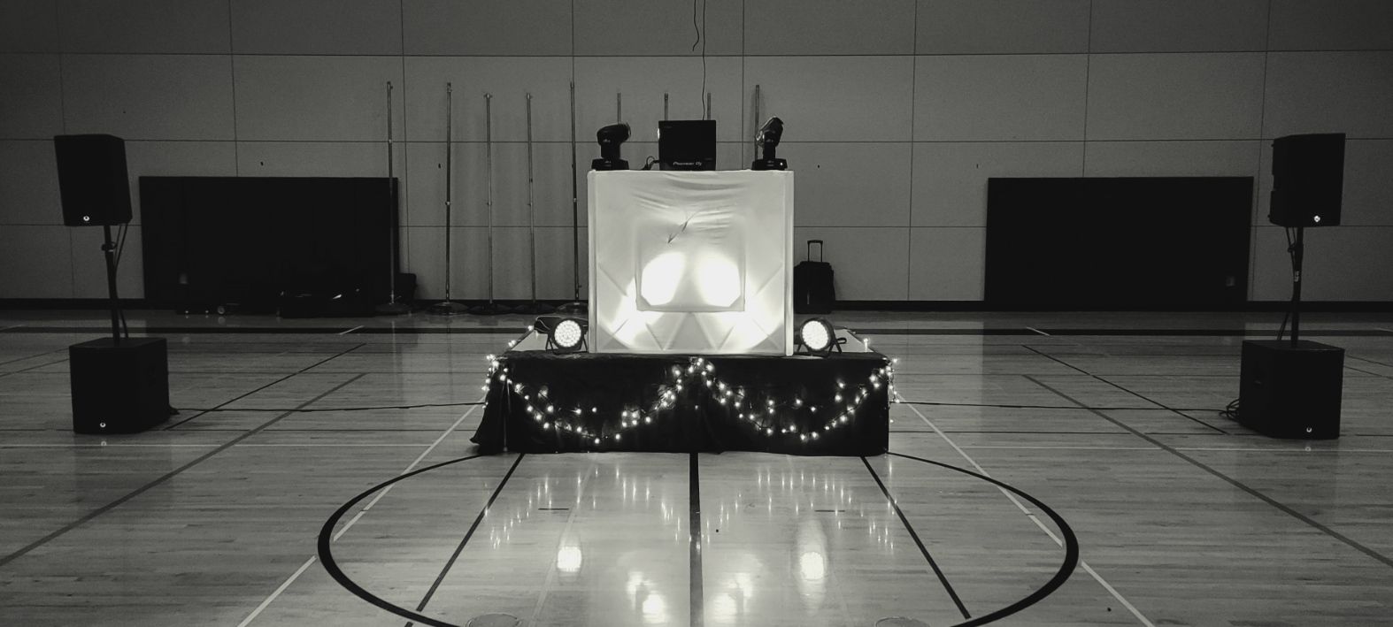 A black and white picture of the DJ booth before before the start of an event. Venue: Silverton High School.