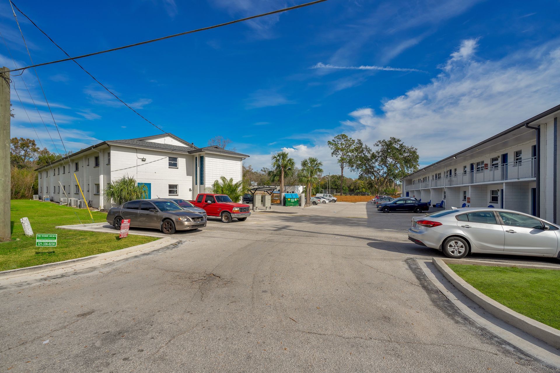 A parking lot with cars parked in front of a building.