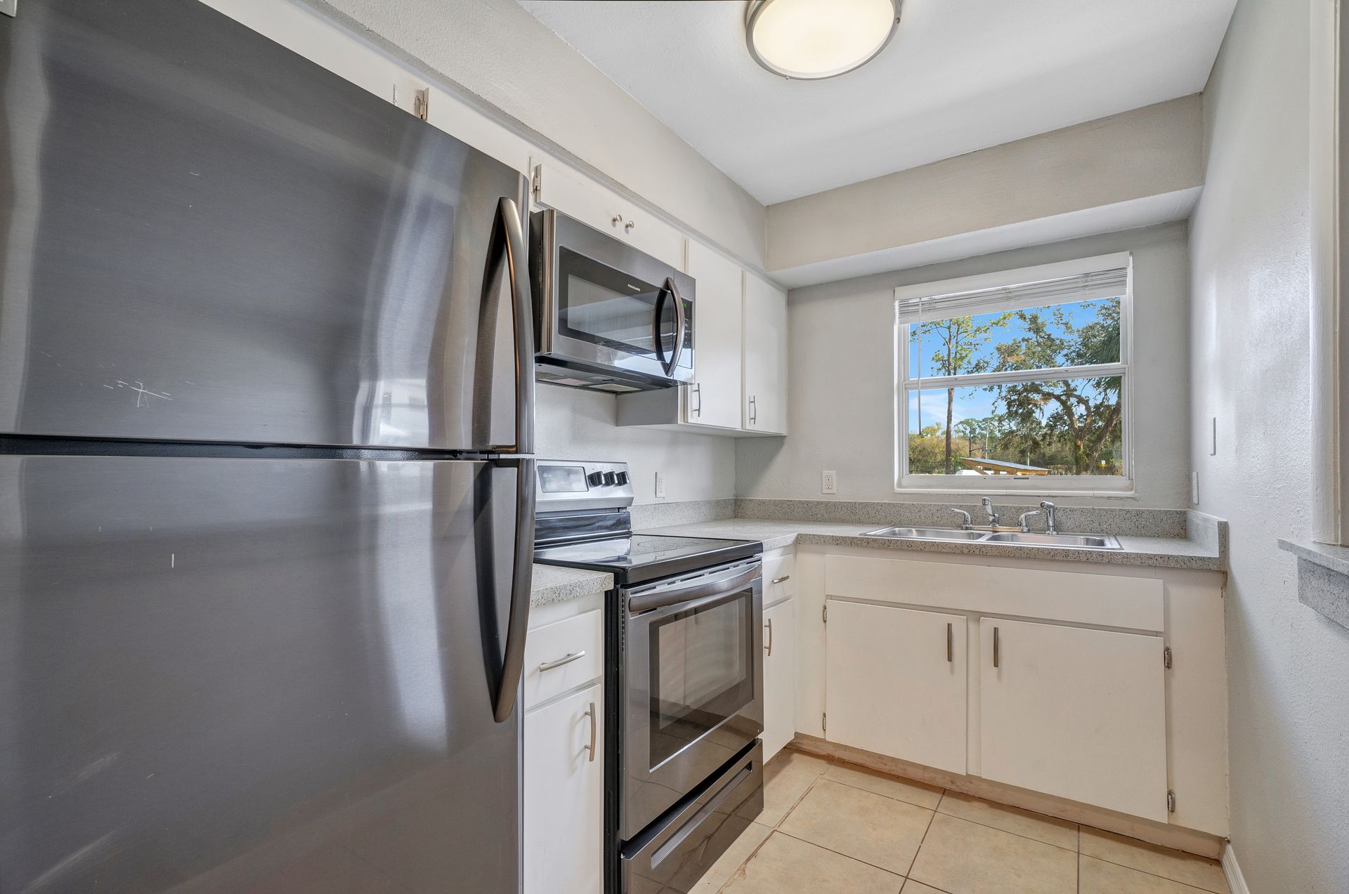 A kitchen with stainless steel appliances and white cabinets.