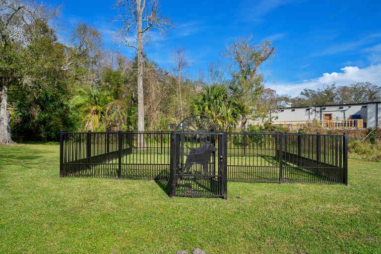 There is a dog fence in the middle of a lush green field.