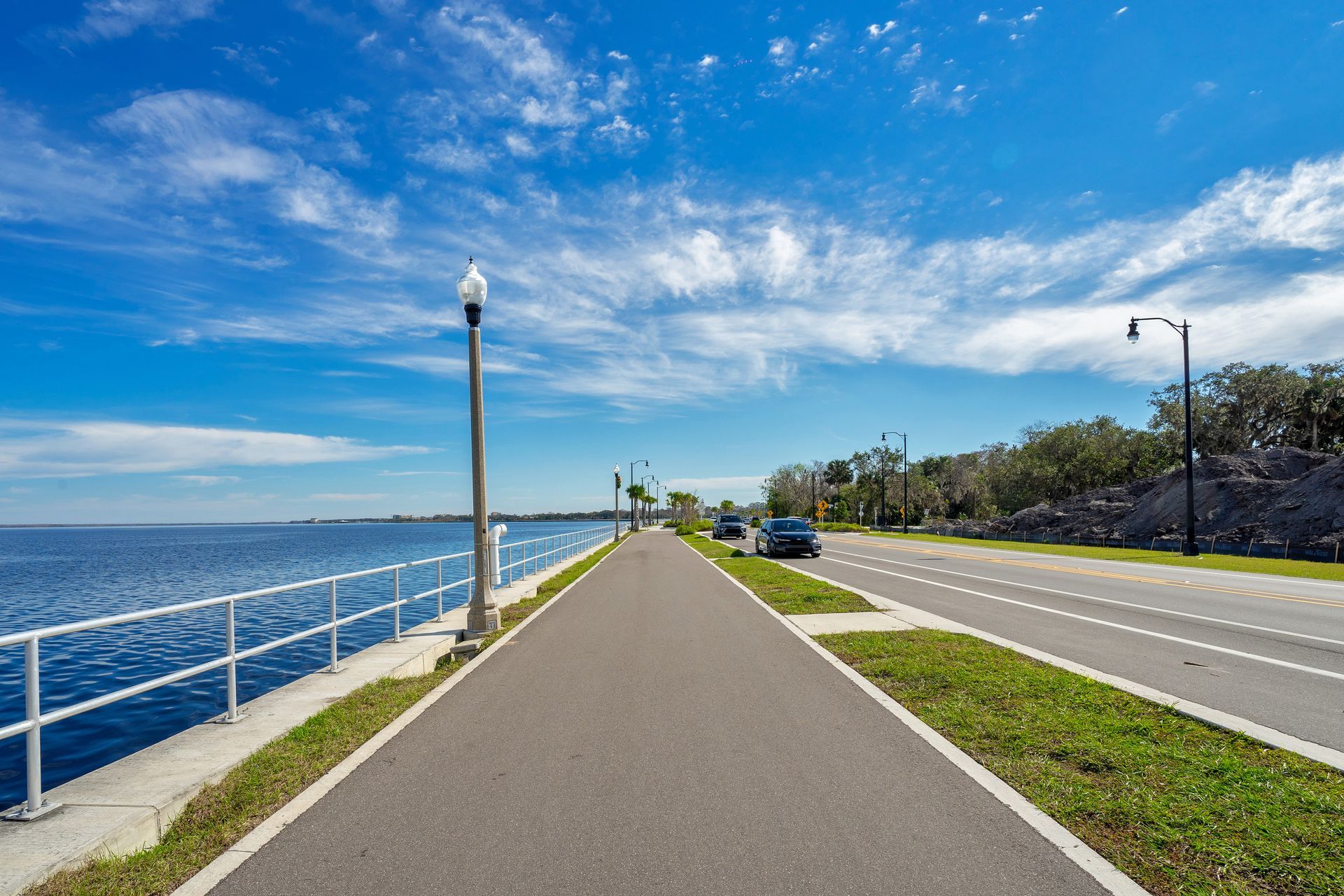 A road leading to a body of water on a sunny day.