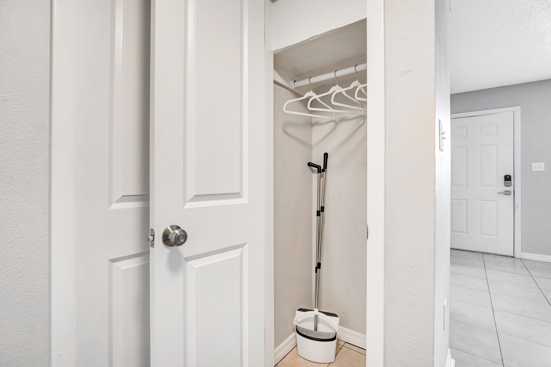 A closet with a coat rack and a basket in it.