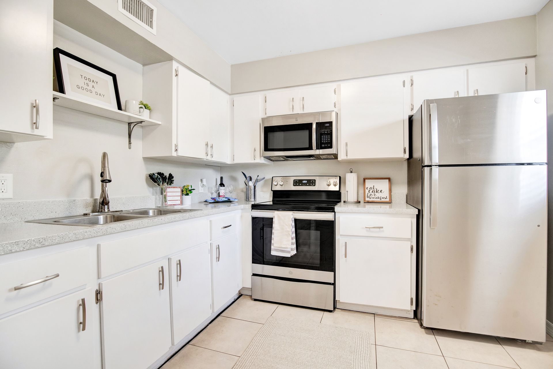 A kitchen with white cabinets and stainless steel appliances.