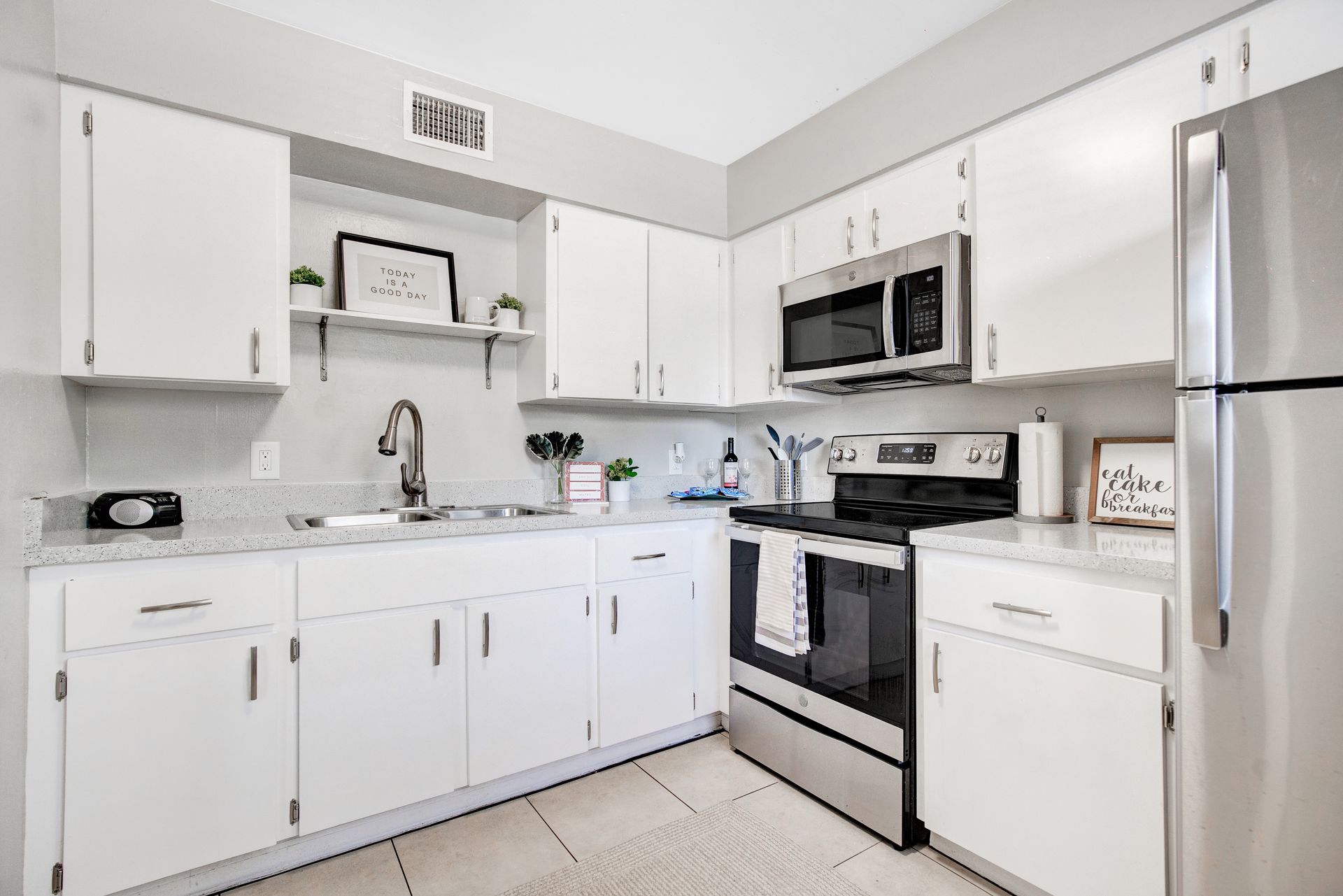 A kitchen with white cabinets and stainless steel appliances.