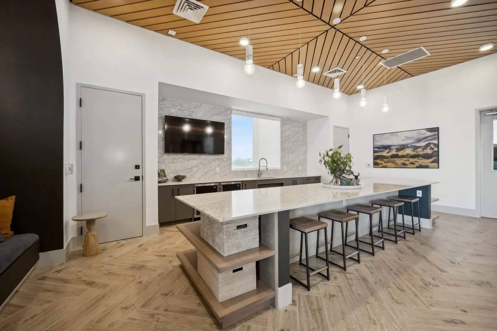 Gather in our stylish community lounge, featuring a sleek kitchen island with bar seating and a modern entertainment area.