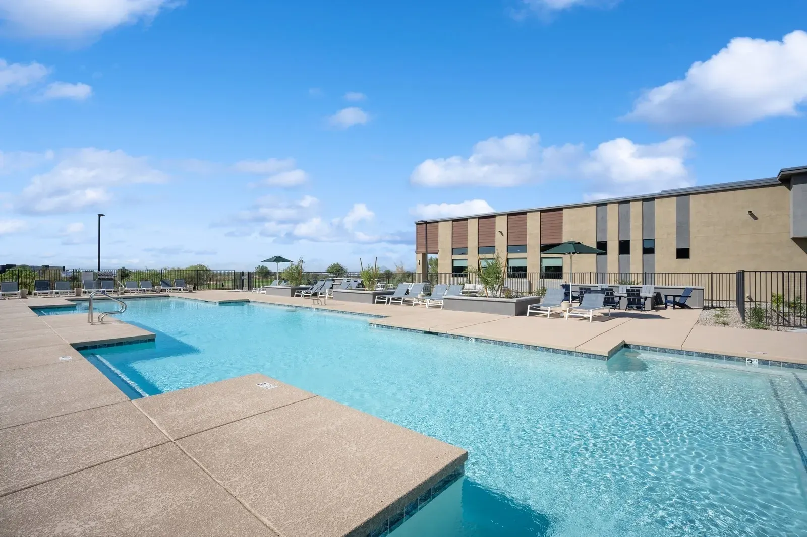 Enjoy a refreshing dip in our sparkling outdoor swimming pool, surrounded by comfortable lounge chairs and lush landscaping. Perfect for relaxing and soaking up the sun.