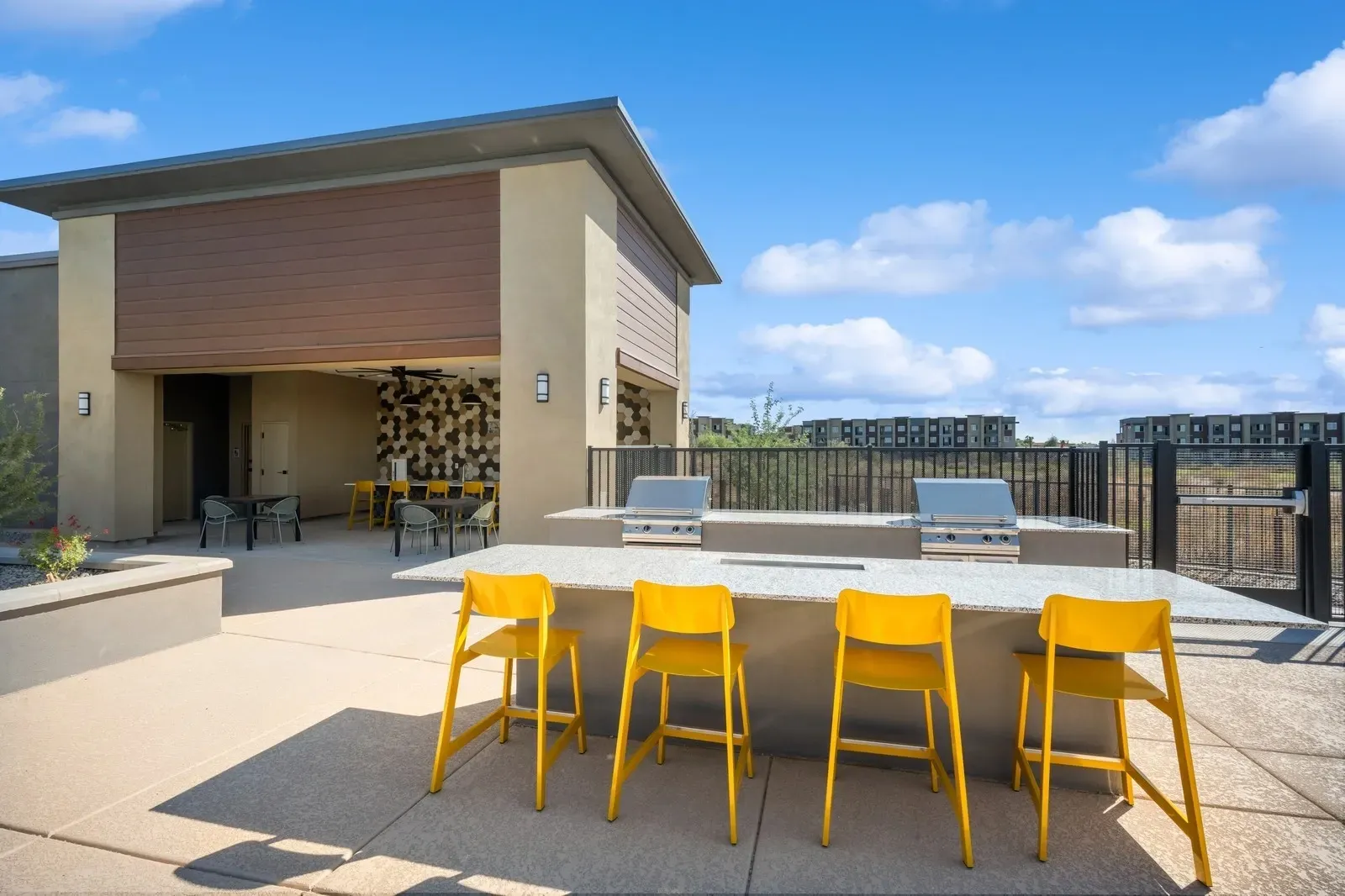 Enjoy outdoor cooking and dining with our modern grilling station, featuring multiple barbecue grills and a spacious counter area.
