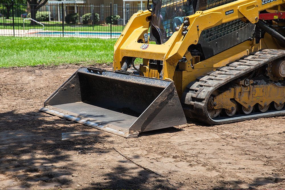A large yellow excavator is demolishing a building.